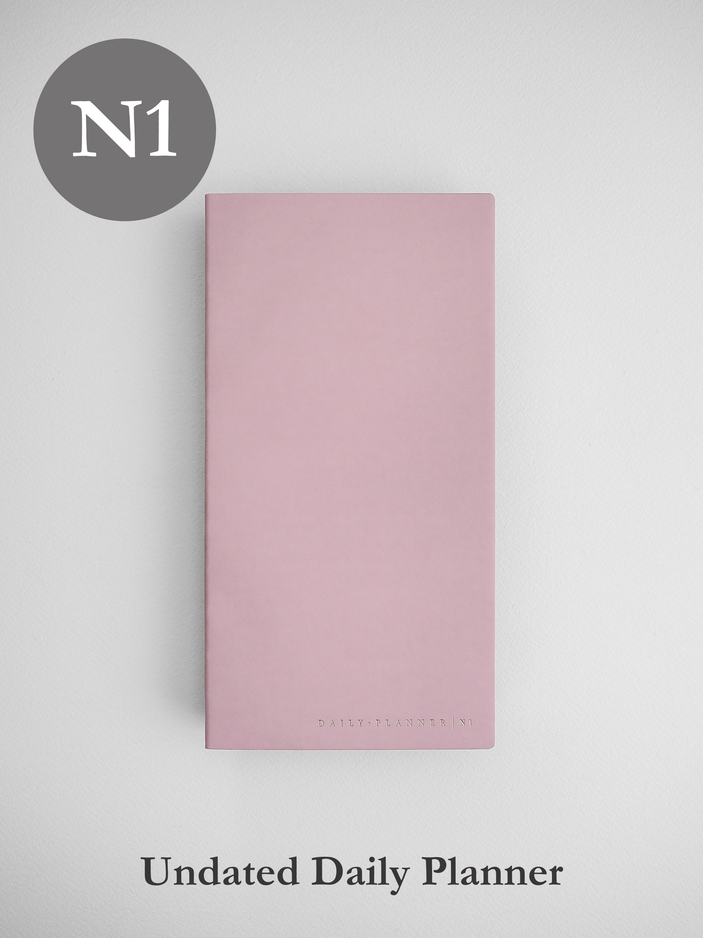 Minimalist undated daily planner cover in soft blush pink, featuring a clean design and subtle branding detail for an elegant aesthetic.