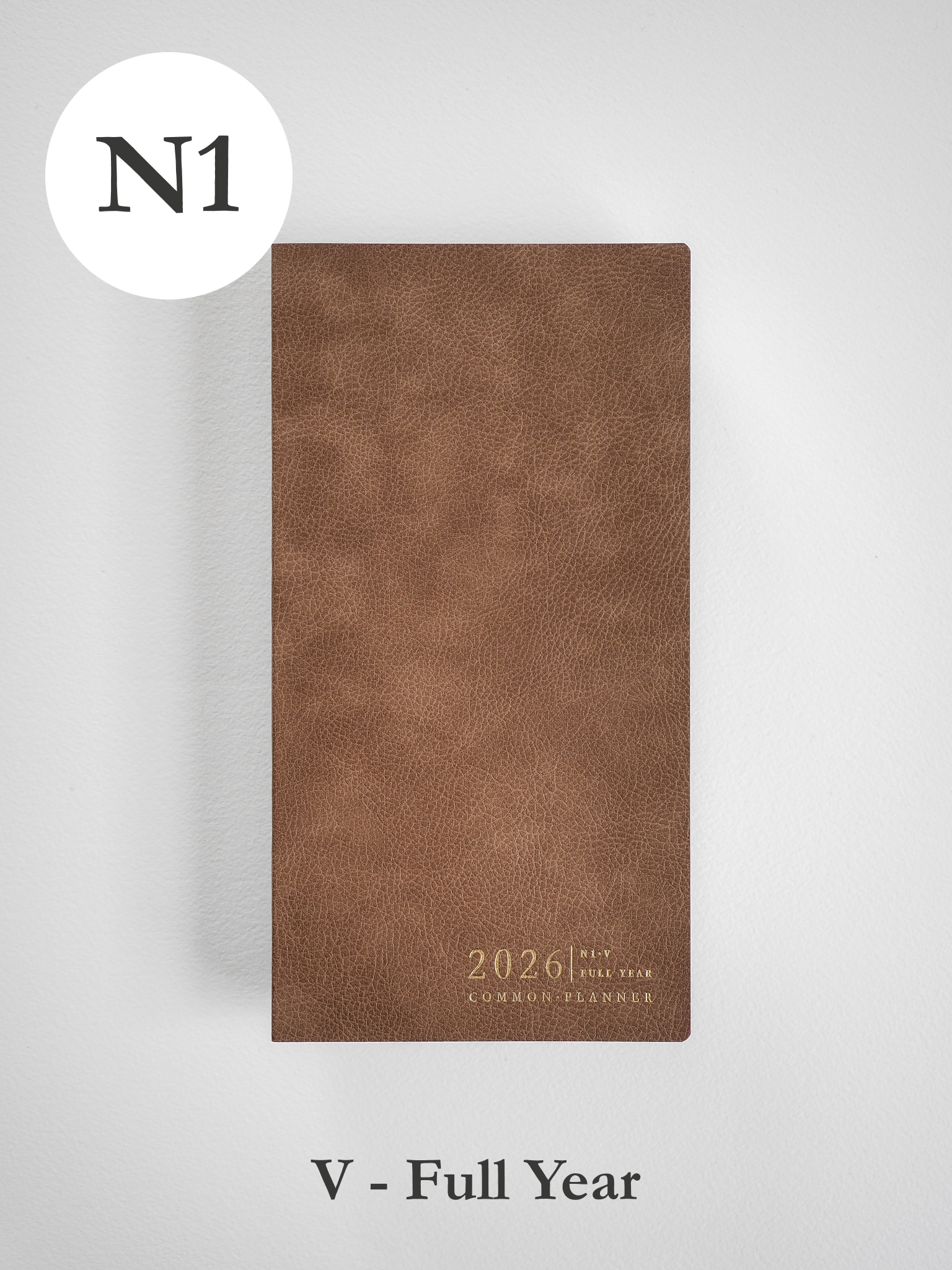 Matte, vertical brown planner cover with a textured, faux-leather finish, featuring elegant gold foil lettering for "2026" and "Common Planner."