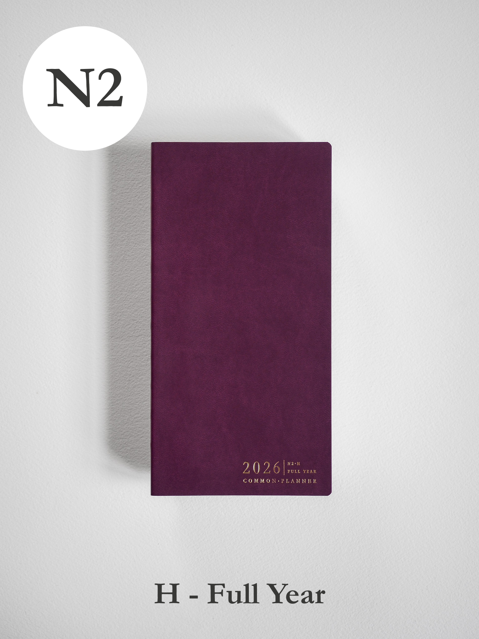 Rich deep burgundy planner cover displaying the embossed year "2026" and the phrase "Common Planner" in elegant gold lettering.