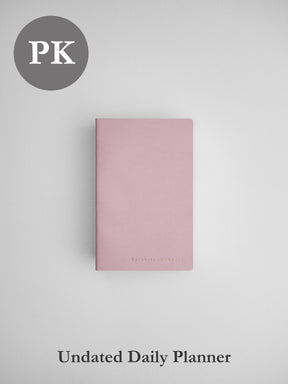 Soft blush pink undated daily planner notebook, featuring a simple, elegant, minimalist matte cover design.