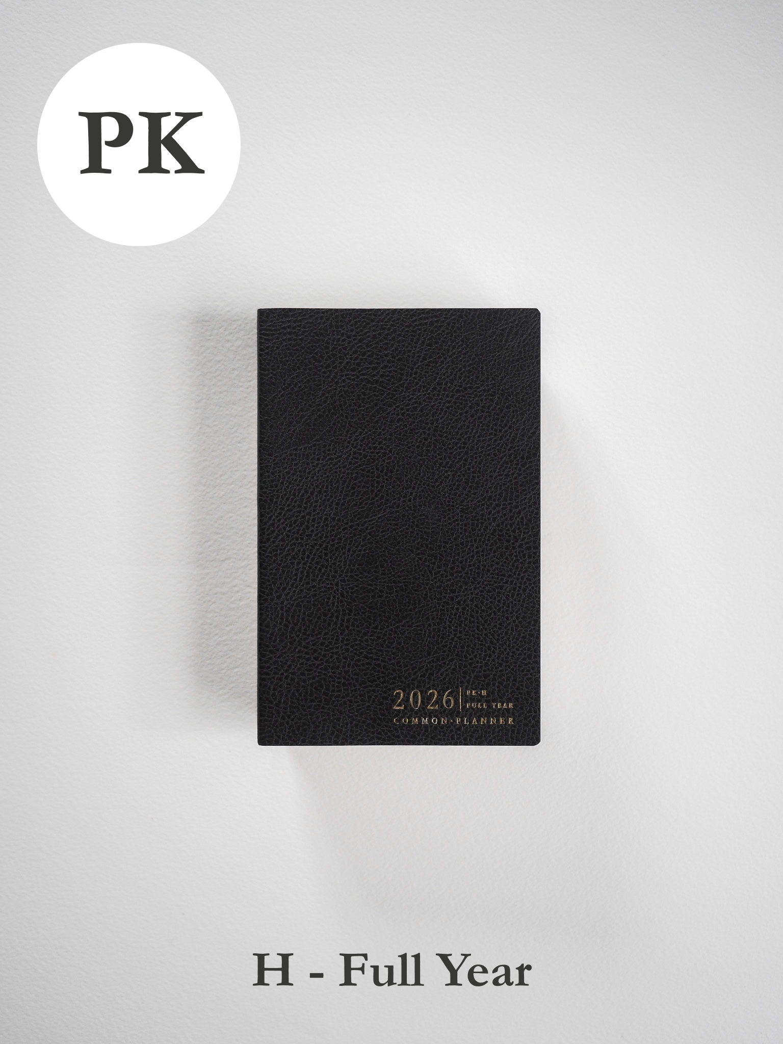 A sleek, black pocket planner featuring a subtly textured cover and the debossed, elegant gold lettering of "2026 Common Planner."