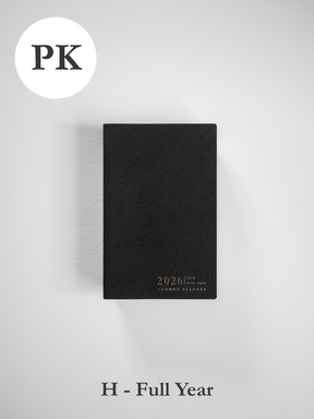 A sleek, black pocket planner featuring a subtly textured cover and the debossed, elegant gold lettering of "2026 Common Planner."