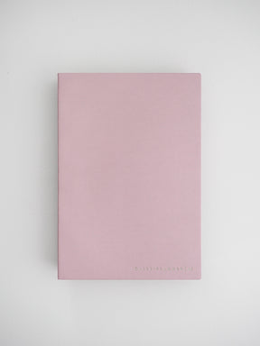 A minimalist, solid blush pink planner cover with the brand name "DAILY PLANNER" debossed near the bottom center.