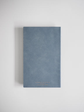Compact A5 slate blue planner featuring a smooth, matte faux leather cover, perfect for full-year organization with subtle embossed branding.