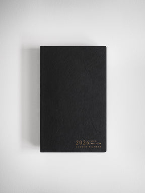 Elegant A5 planner with a matte black cover, featuring sophisticated gold foil stamping for "2026 Common Planner," ready for full-year organization.