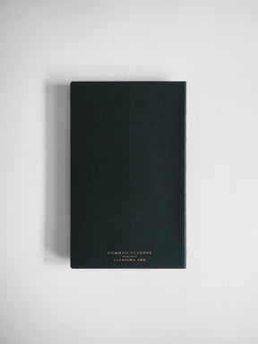 A dark, matte A5 slim planner featuring centered gold foil lettering that reads "COMMON PLANNER designed by STEERING INK."