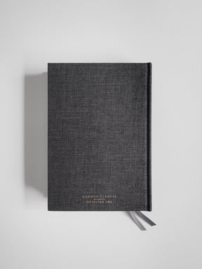A dark charcoal A5 planner featuring subtle, minimalist branding and centered typography reading "Common Planner" and "Designed by Stealing Ink."