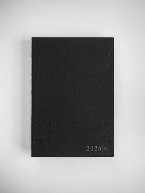 Minimalist black A5 planner cover for 2026, showcasing a sophisticated, matte finish with elegant, centered year typography.