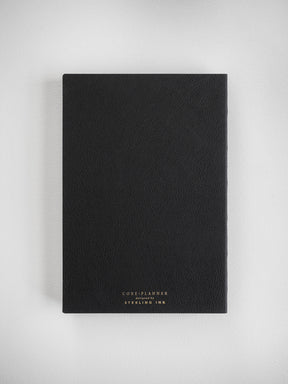 A minimalist A5 vertical core planner in solid black, featuring debossed text on the front cover that reads "CORE PLANNER, designed by STERLING INK."