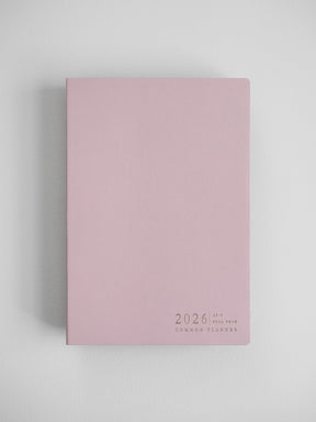 Elegant blush pink A5 planner featuring centered black typography that reads "2026 A5 Full Year Common Planner."