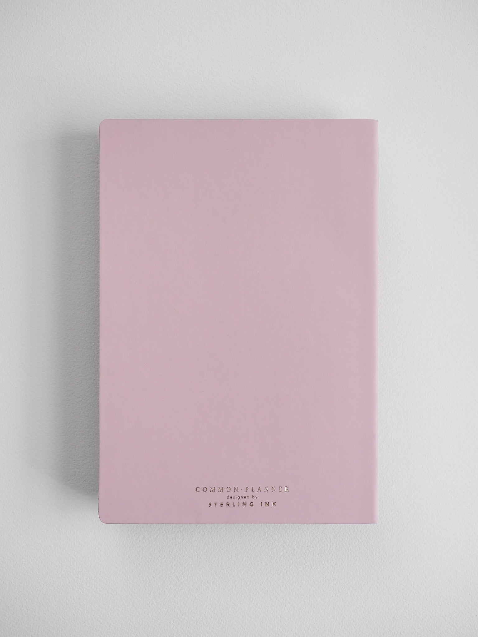 Soft blush pink A5 planner cover for 2026, featuring centered elegant lettering that reads "Common Planner designed by Sterling Ink."