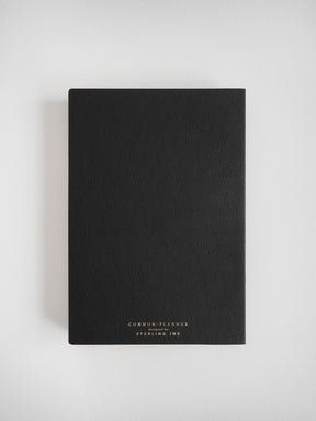 Matte black faux-leather journal featuring minimal white branding for the "Common Planner," identifying it as a planner designed by Sterling Ink.