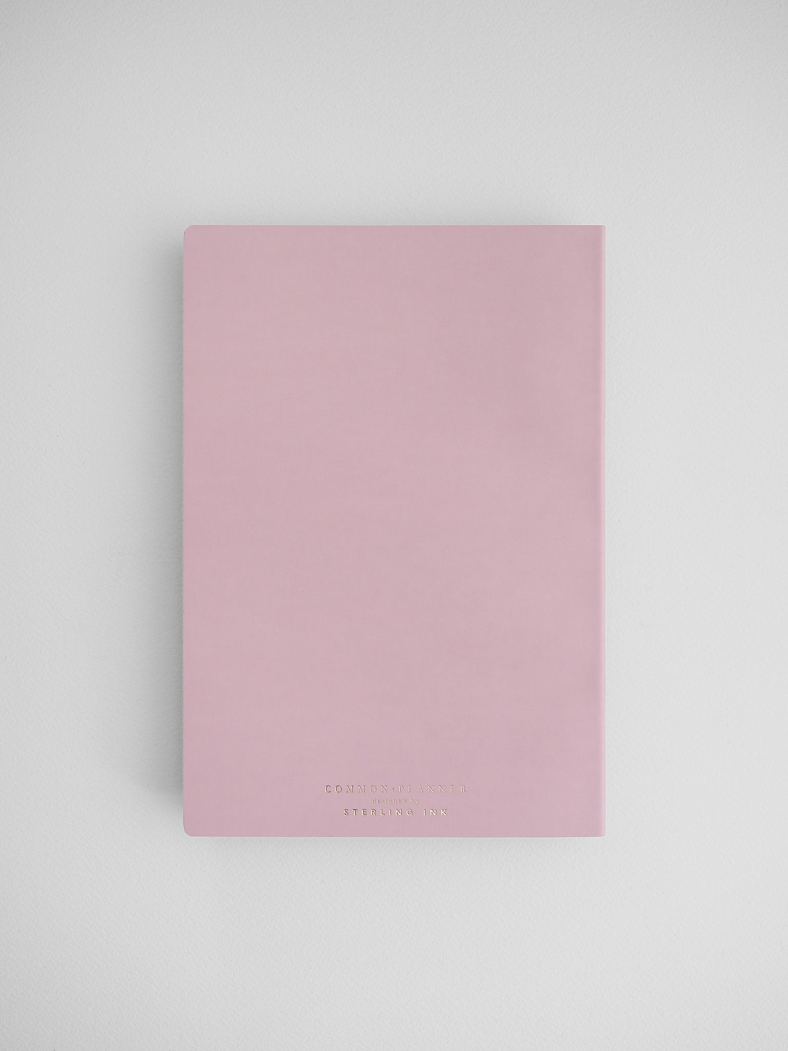 Pale pink, vertically oriented planner journal featuring minimalist, elegant typography branding for the "Common Planner."