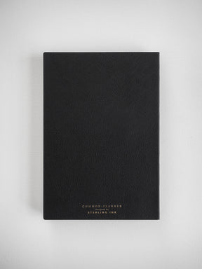 Minimalist black planner bound in faux leather, featuring centralized gold foil stamping that reads "COMMON PLANNER by STERLING INK."