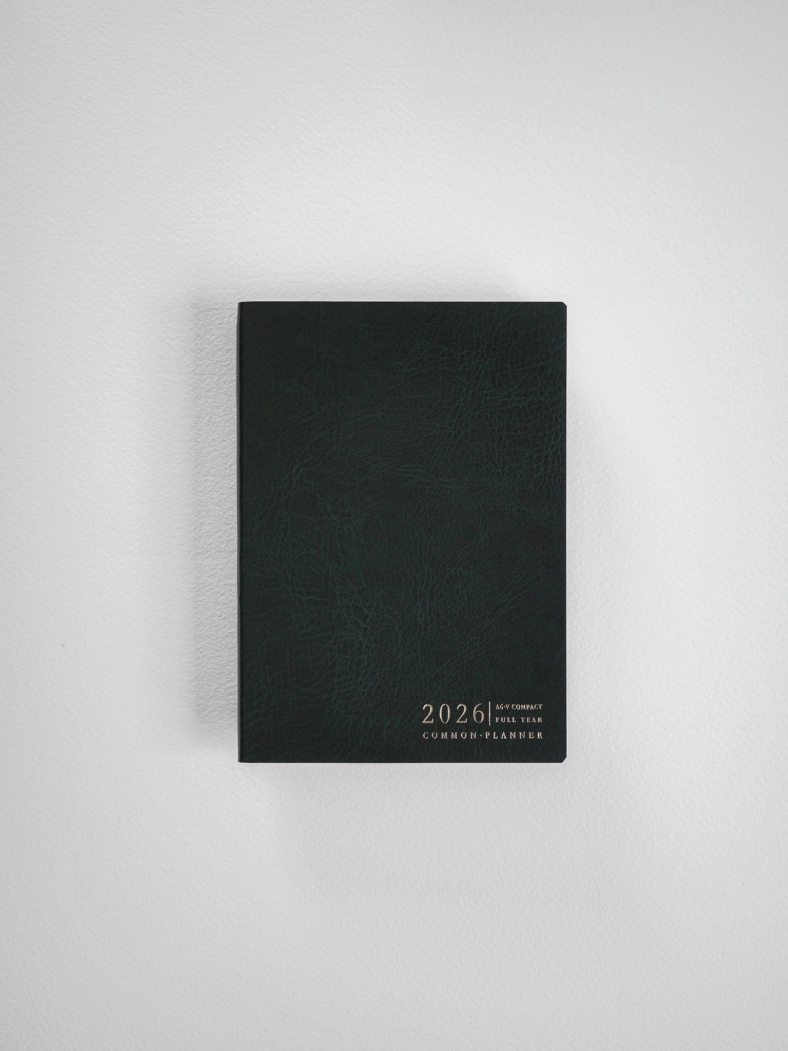 Sleek, black compact planner cover displaying minimalist embossed text that reads "2026 Compact Full Year Common Planner."