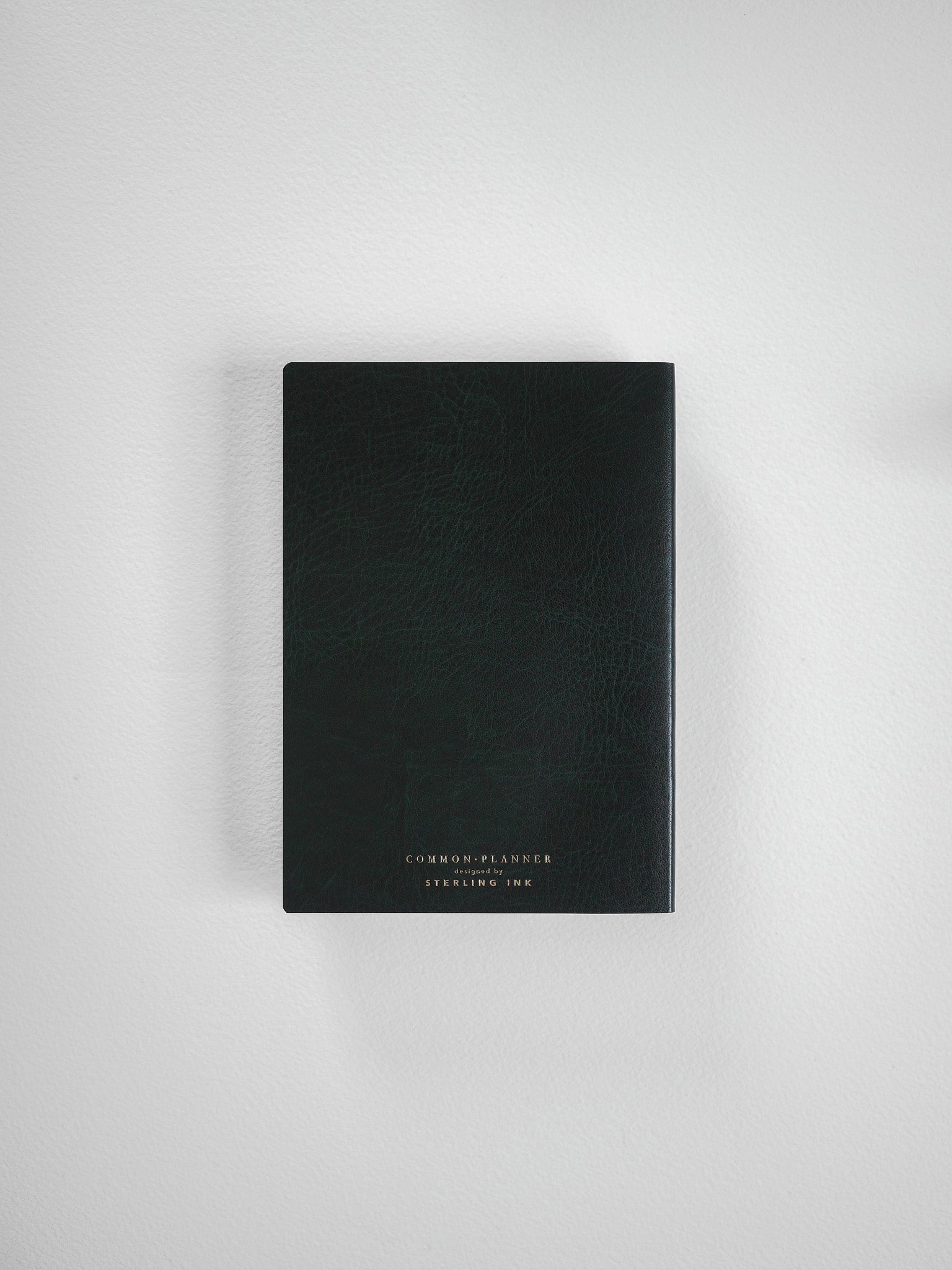Dark matte A6 vertical planner for 2026, featuring centered white branding text: "COMMON PLANNER" by Sterling Ink.