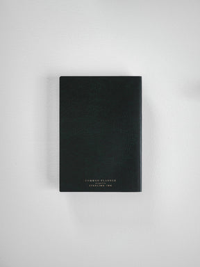 Dark matte A6 vertical planner for 2026, featuring centered white branding text: "COMMON PLANNER" by Sterling Ink.