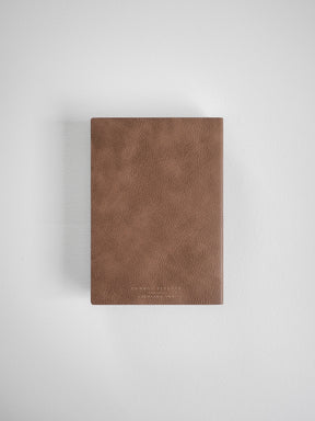 A minimalist A6 vertical planner with a textured, matte taupe brown cover, designed for full year scheduling in 2026.