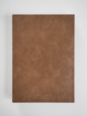 A textured, rich mocha brown faux leather planner cover featuring minimalist debossed lettering for the Common Planner 2026 journal.