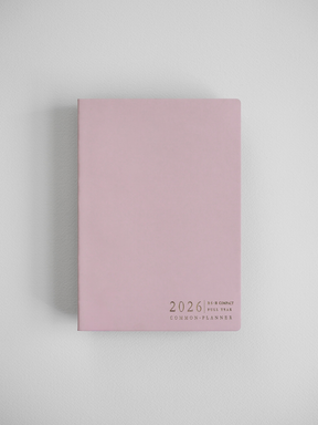 Minimalist B6 planner cover in soft pastel pink, featuring centered black typography that reads "2026 B6 Compact Full Year Common Planner."
