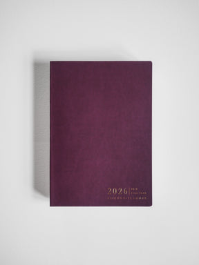 A deep burgundy B6 planner cover featuring elegant gold foil embossing that reads "2026 Full Year Common Planner."