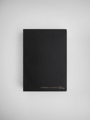 Sleek matte black planner cover that displays "Common Planner Full Year" text, perfect for minimalist undated journaling or scheduling.