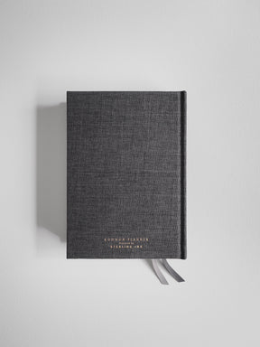 Dark gray B6 planner journal with a subtle textured cover, prominently featuring the gold-lettering title "Common Planner" and "Designed by Sterling Ink."