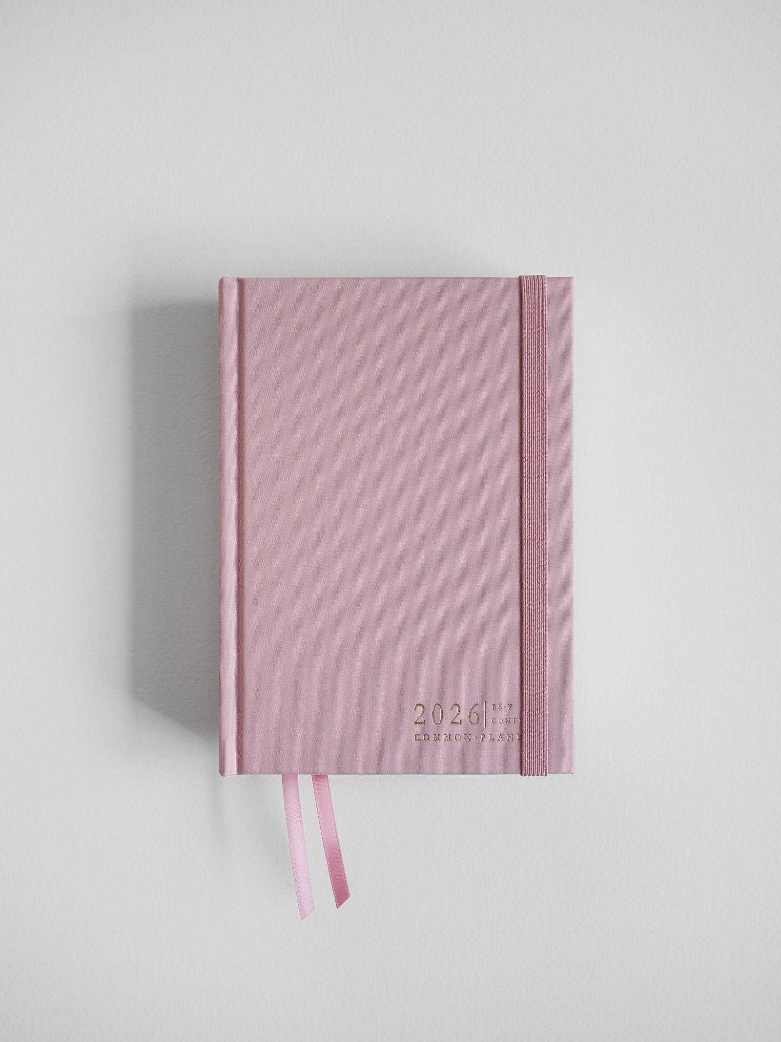 Pastel blush pink B6 2026 vertical planner featuring simple typography and matching decorative ribbon accents for comprehensive yearly planning.