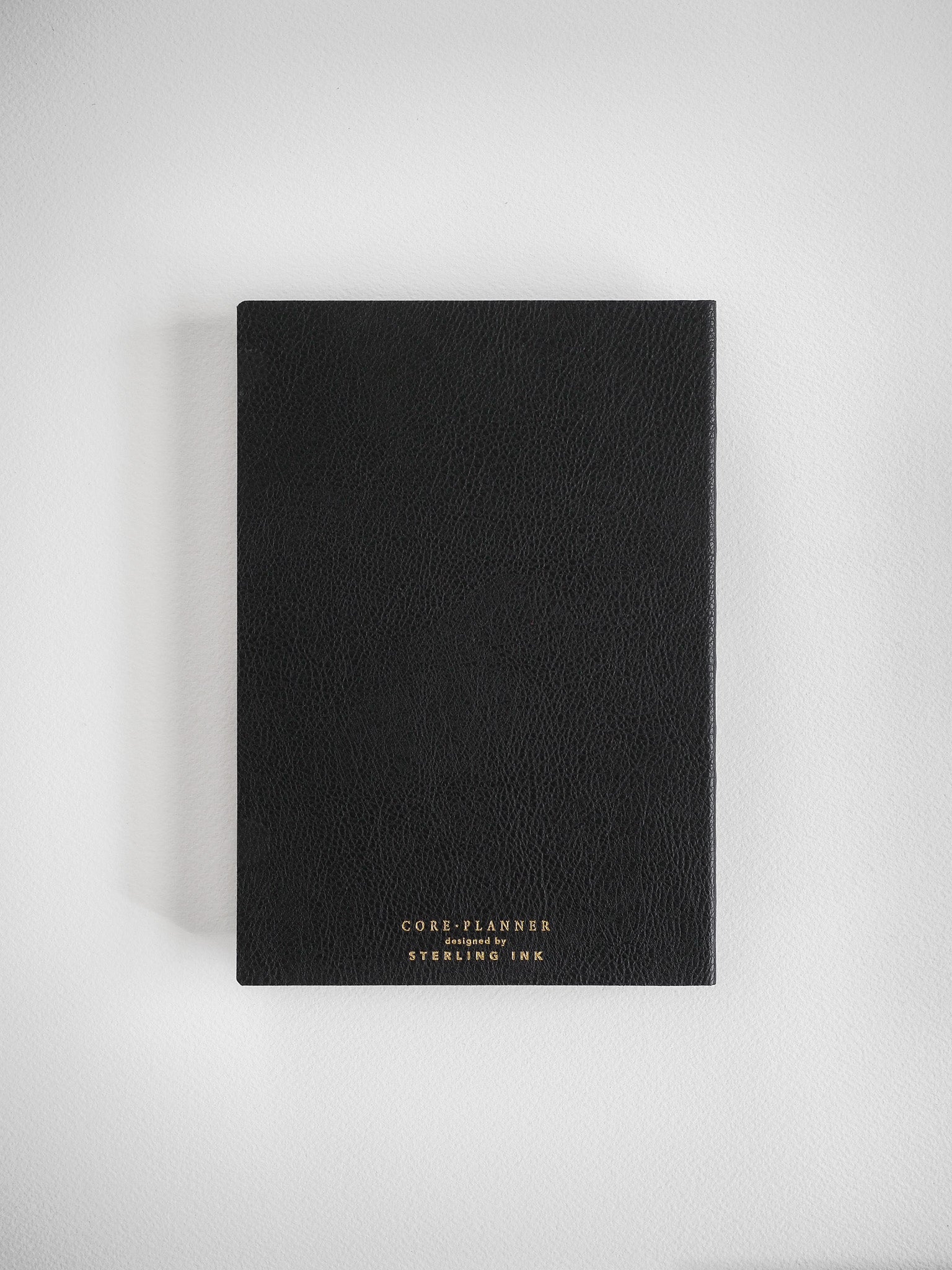 Structured black B6 planner featuring subtle text embossing for the "CORE PLANNER" series, designed by Sterling Ink for organized yearly planning.