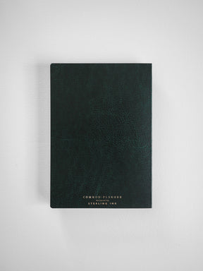 Dark, textured planner cover with a sophisticated matte finish and minimalist white lettering that reads 'COMMON PLANNER' and 'designed by STERLING INK'.