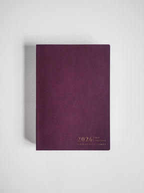 Minimalist B6 planner featuring a deep plum cover with gold foil lettering displaying "2026 Full Year Common Planner."