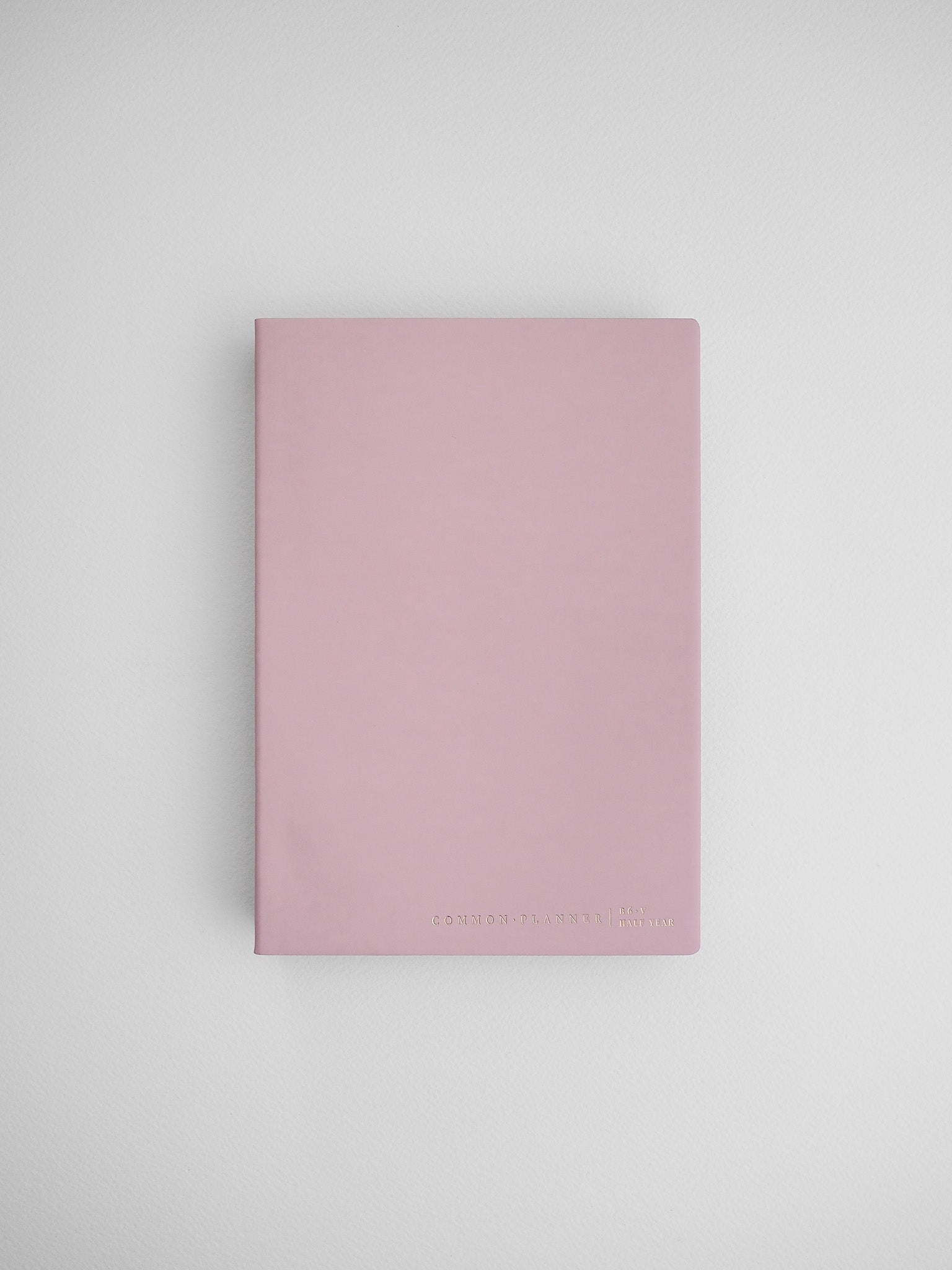 Minimalist B6 half-year planner featuring a dusty rose cover, marked with "Common Planner," ideal for tracking schedules or journaling.