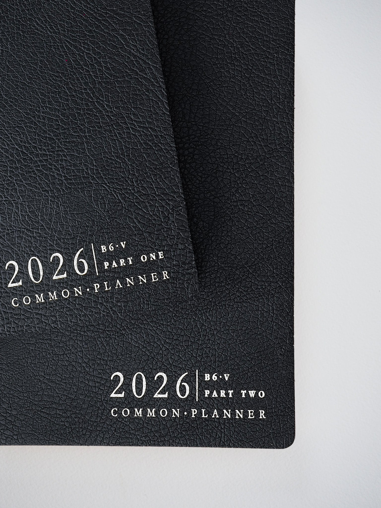 Black faux-leather planner bundle for 2026, featuring two matching B6 covers labeled 'Part One' and 'Part Two' in elegant, coordinating typography.