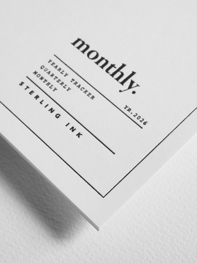 Elegant, monochrome planner insert with clean lines and centered black typography marking "monthly." alongside trackers for yearly, quarterly, and monthly scheduling for 2026.