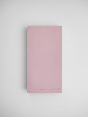 Minimalist blush pink compact planner featuring a soft solid color and subtle "Common Planner" branding, perfect for undated journaling or organization.