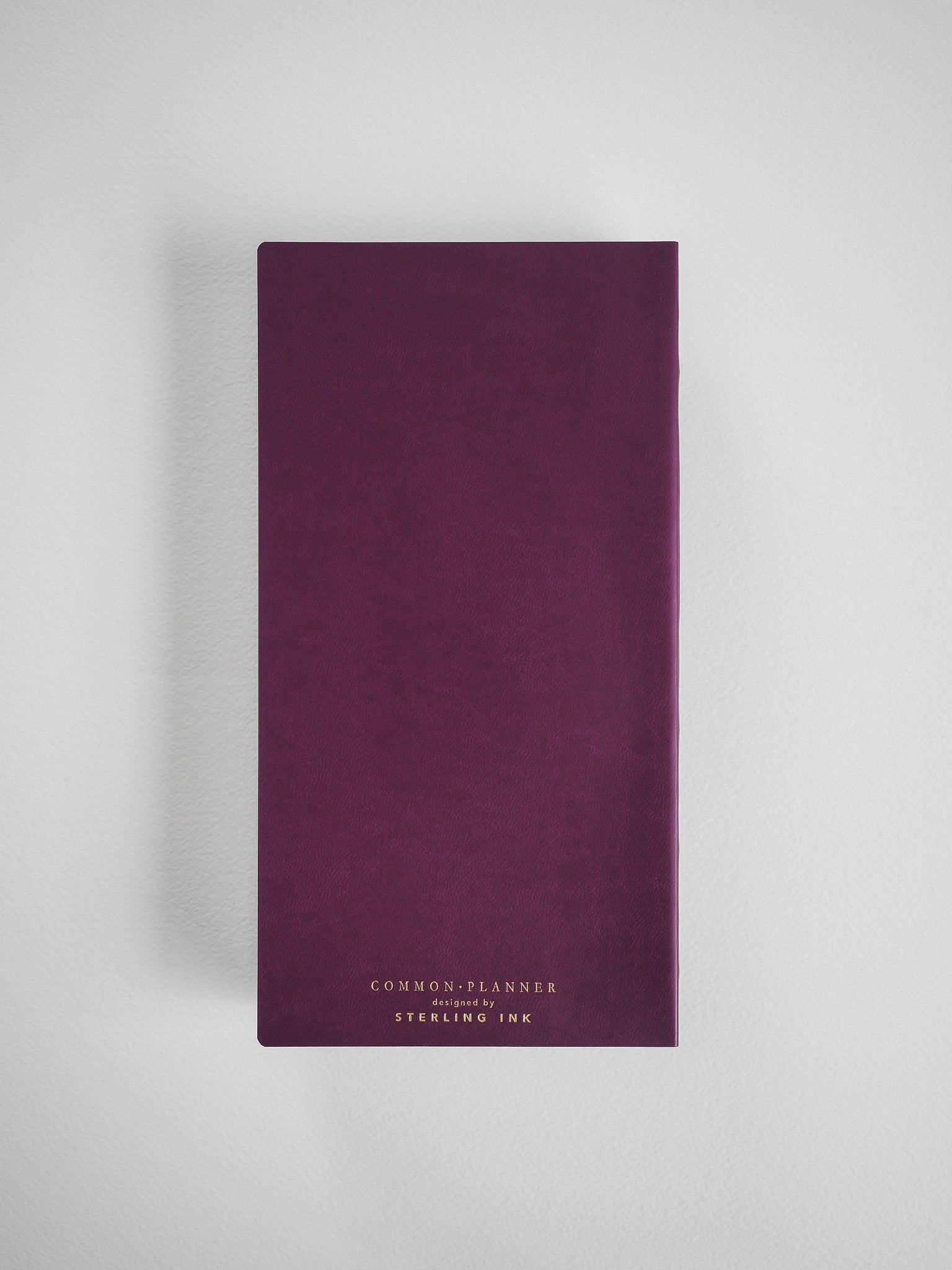 Dusty magenta planner featuring elegant white typography that reads "COMMON PLANNER designed by STERLING INK," ready for the 2026 year.