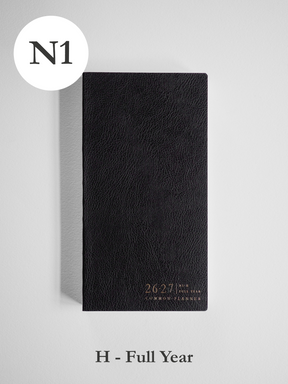 Black, textured faux-leather academic planner displaying "2026-2027" and "Common Planner" in stylish gold lettering.