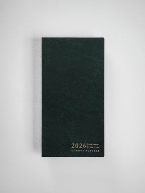 Dark forest green compact planner featuring debossed text reading "2026 N1 V COMPACT FULL YEAR COMMON PLANNER" centered on the cover.