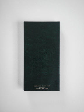 Dark forest green planner featuring a subtle textured faux leather finish and debossed gold lettering that reads 'COMMON PLANNER designed by STERLING INK'.