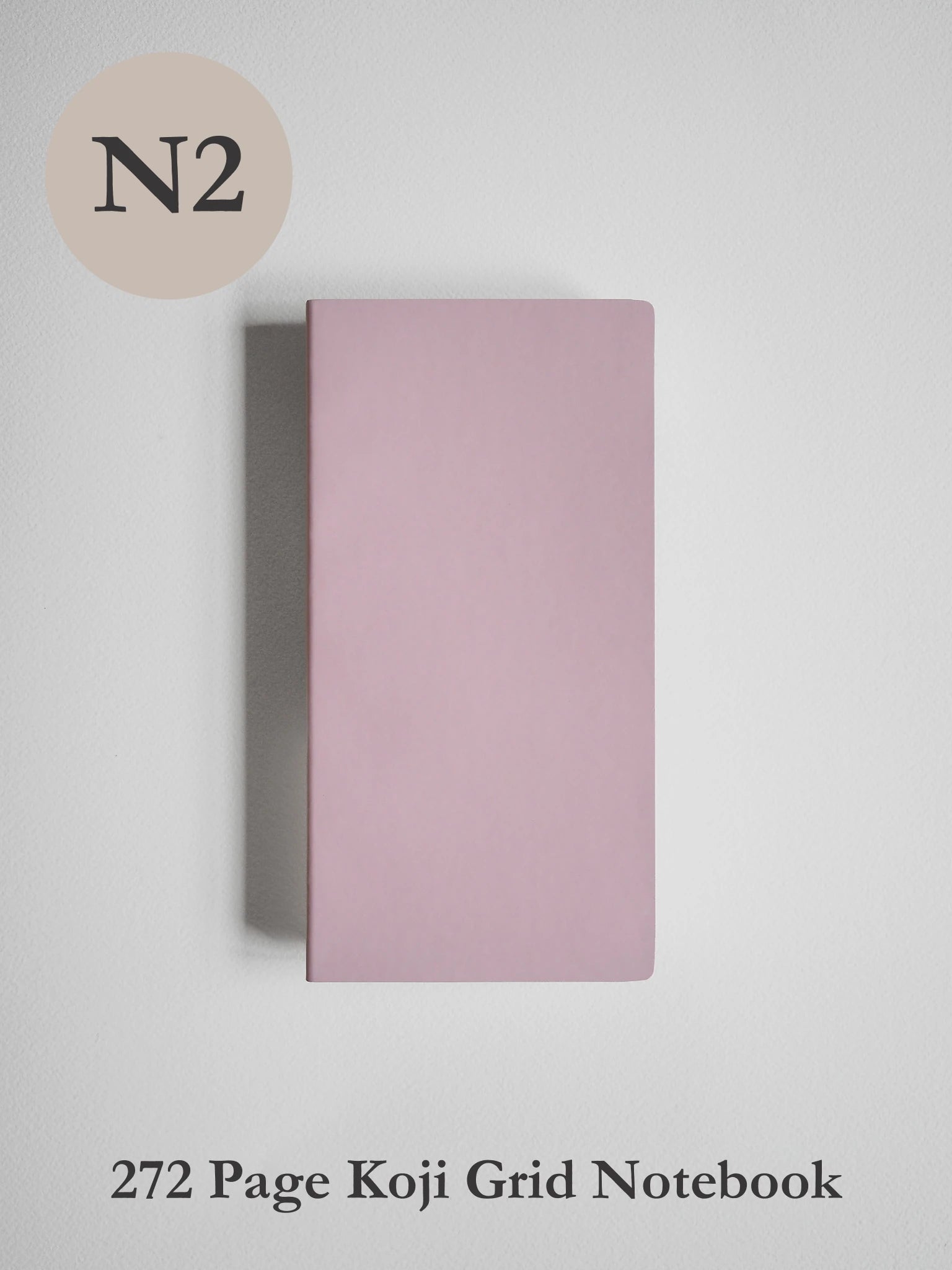 A dusty pink notebook with a minimalist cover design, shown vertically against a light gray background. Text overlays indicate 'N2' in a beige circle at the top left and '272 Page Koji Grid Notebook' at the bottom.
#Color_Fairyfloss