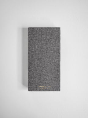 Sophisticated horizontal planner bound in textured charcoal gray material, designed for comprehensive full year planning in 2026.