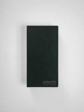 Elegant vertical planner featuring a dark, textured cover printed with the white text "2026 N2 Compact Full Year Common Planner."