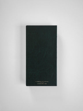 A compact, vertical planner featuring a deep charcoal, textured faux-leather cover, with centered white text branding for 'Common Planner' and 'Sterling Ink'.