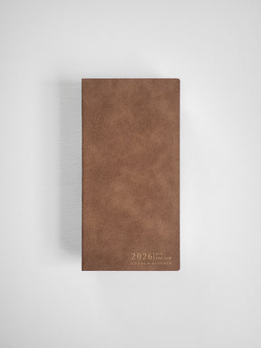 Rich, deep brown vertical planner cover with a faux leather texture, subtly debossed with "2026 Full Year Common Planner" in a minimalist design.