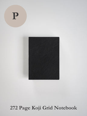 A black textured notebook with a grid layout and 272 pages, shown closed on a light gray background. A beige circle containing the letter 'P' is in the top-left corner, and the text '272 Page Koji Grid Notebook' is at the bottom.
#Color_Onyx