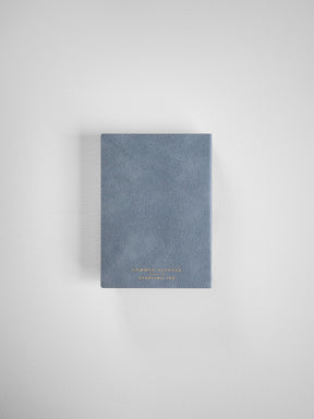 A compact, horizontal planner featuring a muted slate gray cover and elegant gold foil lettering of the "Common Planner" brand.
