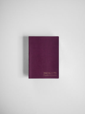 A compact, solid burgundy planner cover displaying white text detailing the "2026 P.H. Compact Full Year Common Planner."