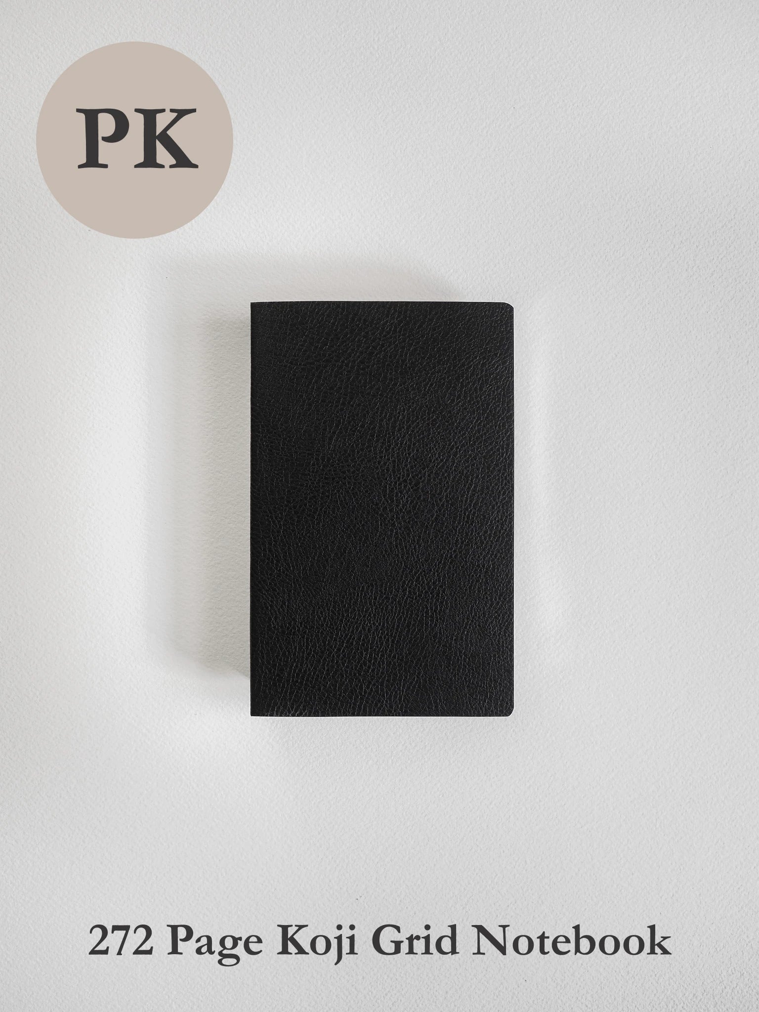 A black textured notebook with a grid layout, shown closed on a light gray background. A beige circle in the top-left corner contains the letters 'PK', and the text '272 Page Koji Grid Notebook' is printed at the bottom.
#Color_Onyx