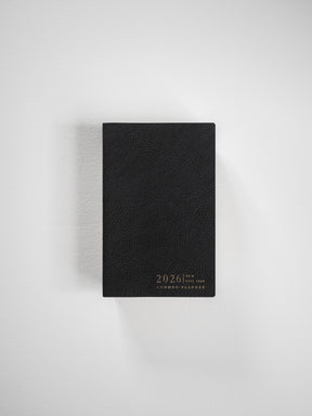 The black horizontal pocket planner features a textured faux leather cover and elegant gold lettering displaying "2026 Common Planner."