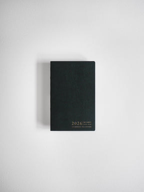 Compact, vertical black planner with a sleek, minimalist design and gold foil text displaying "2026," "POCKET," and "COMMON PLANNER."